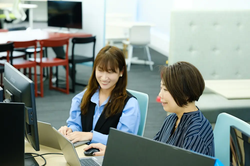 ノートパソコンの前で話す社員