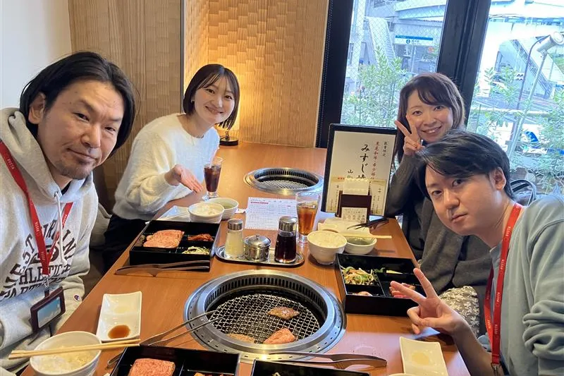 焼肉店でのシャッフルランチ会で談笑する社員