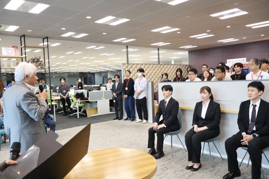 新入社員が並んで座る入社式の様子