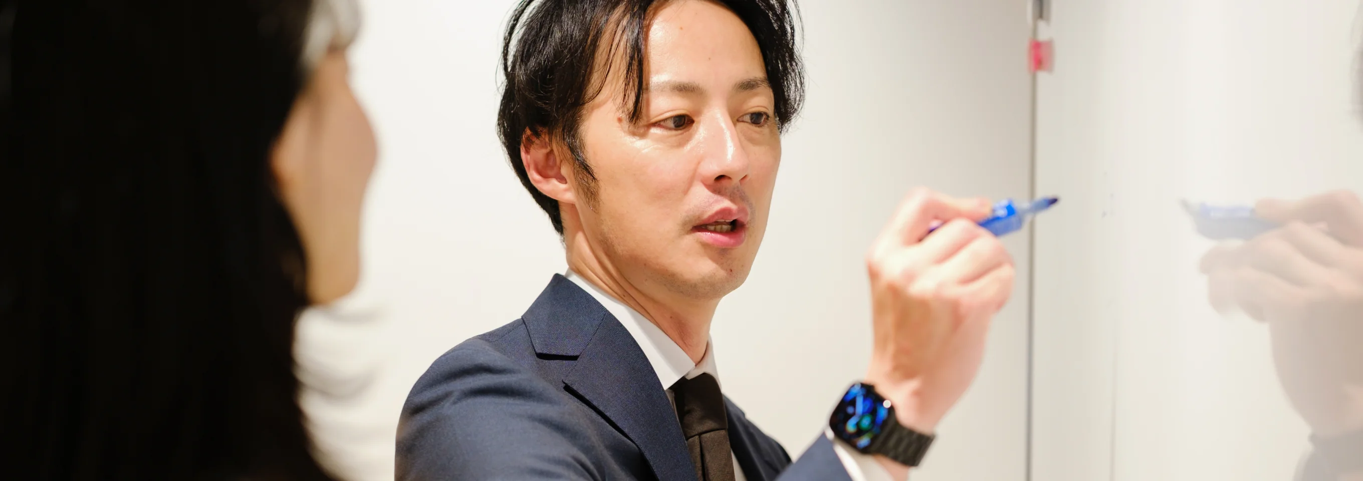 マーカーを手に説明する社員