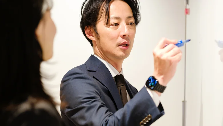 マーカーを手に説明する社員
