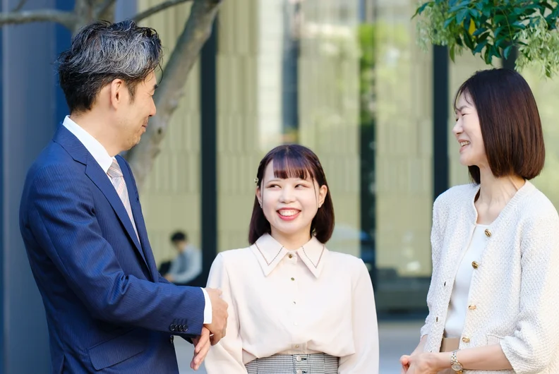 屋外で笑顔で会話する社員たち